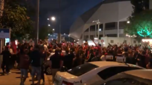 المئات من مشجعي نادي كرة القدم هابوعيل تل أبيب يحتفلون بفوز الفريق خارج ملعب بلومفيلد في تل أبيب، دون الالتزام بقواعد التباعد الاجتماعي، 2 يونيو 2020 (Screenshot: Twitter)