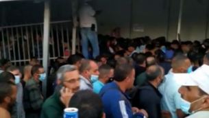 عمال فلسطينيون في طريقهم إلى العمل في إسرائيل، عند حاجز 300 في بيت لحم بالضفة الغربية، يونيو 2020.(Screenshot: Channel 12)