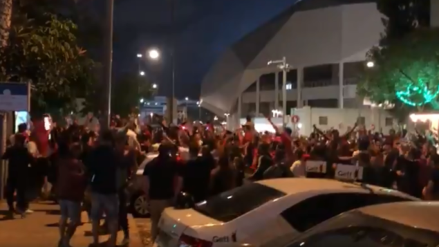 المئات من مشجعي نادي كرة القدم هابوعيل تل أبيب يحتفلون بفوز الفريق خارج ملعب بلومفيلد في تل أبيب، دون الالتزام بقواعد التباعد الاجتماعي، 2 يونيو 2020 (Screenshot: Twitter)