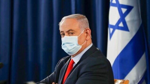 Israeli Prime Minister Benjamin Netanyahu, wearing a protective face mask, chairs the weekly cabinet meeting in Jerusalem on May 31, 2020. (Photo by RONEN ZVULUN / POOL / AFP)