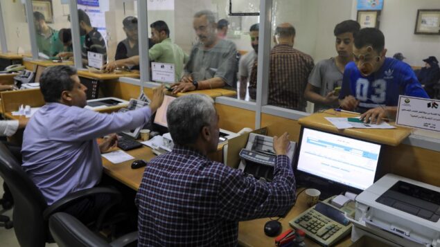 فلسطينيون يتلقون مساعدات مالية من قطر في مكتب بريد في مدينة غزة، 27 يونيو 2020. (Mahmud Hams/AFP)