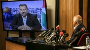 المسؤول الرفيع في فتح جبريل رجوب، في مدينة رام الله بالضفة الغربية، خلال اجتماع عبر الفيديو مع نائب رئيس حماس صالح العاروري (على الشاشة من بيروت) لمناقشة خطة إسرائيل لضم أجزاء من الضفة الغربية، 2 يوليو 2020. (ABBAS MOMANI / AFP)