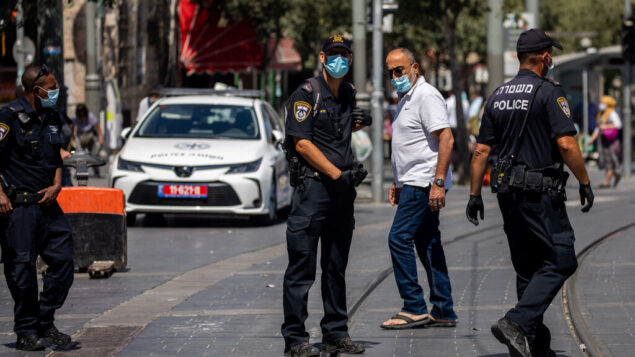ضباط الشرطة يقومون بدورية خارج سوق محانيه يهودا في القدس لفرض قواعد الطوارئ لكوفيد-19، 3 يوليو 2020. (Yonatan Sindel / Flash90)