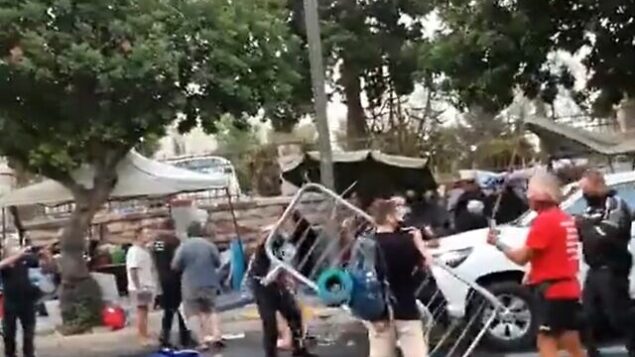 عناصر من الشرطة ومراقبو بلدية يشتبكون في متظاهرين بالقرب من مقر الإقامة الرسمي لرئيس الوزراء بنيامين نتنياهو في القدس، 13 يوليو، 2020. (Screen grab/Twitter)