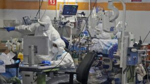 مسعفون يعملون مع مرضى كوفيد-19 في جناح العزل بمركز شيبا الطبي في رمات غان، 29 يوليو 2020. (JACK GUEZ / AFP)