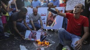 فلسطينيون في مدينة رام الله بالضفة الغربية يحرقون صور ولي العهد الإماراتي الشيخ محمد بن زايد آل نهيان (في الأعلى) وولي العهد السعودي الأمير محمد بن سلمان، خلال مظاهرة ضد الاتفاق الإماراتي - الإسرائيلي على تطبيع العلاقات الدبلوماسية، 15 أغسطس، 2020.  (Abbas Momani/AFP)