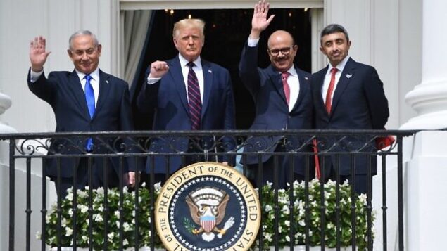 رئيس الوزراء الإسرائيلي بنيامين نتنياهو والرئيس الأمريكي دونالد ترامب ووزير الخارجية البحريني عبد اللطيف الزياني ووزير الخارجية الإماراتي عبد الله بن زايد آل نهيان يلوحون من شرفة ترومان بالبيت الأبيض بعد مشاركتهم في توقيع ’اتفاقية إبراهيم’  التي تعترف من خلاله البحرين والإمارات العربية المتحدة تعترف بإسرائيل ، في البيت الأبيض في واشنطن العاصمة، 15 سبتمبر، 2020. (SAUL LOEB / AFP)