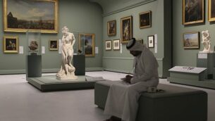 رجل إماراتي يجلس بالقرب من تمثال ’باثر’، الذي يُطلق عليه أيضا اسم ’فينوس’ للنحات الفرنسي كريستوف غابرييل أليغرين، 1710-1795، في متحف اللوفر أبو ظبي، الإمارات العربية المتحدة، 19 ديسمبر، 2017.(AP Photo/Kamran Jebreili)