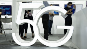 زوار يرتدون أقنعة للحماية من فيروس كورونا يمرون خلف لافتة 5G في معرض بكين الدولي للتكنولوجيا الفائقة في بكين، الصين، 17 سبتمبر 2020 (AP Photo / Ng Han Guan)