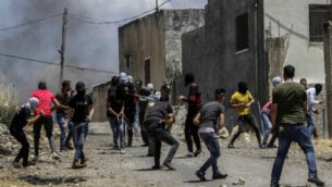 اشتباكات بين فلسطينيين وجنود إسرائيليين خلال احتجاج على خطة إسرائيل لضم أجزاء من الضفة الغربية، في قرية كفر قدوم، بالقرب من مدينة نابلس بالضفة الغربية، 19 يونيو، 2020. (Nasser Ishtayeh / Flash90)