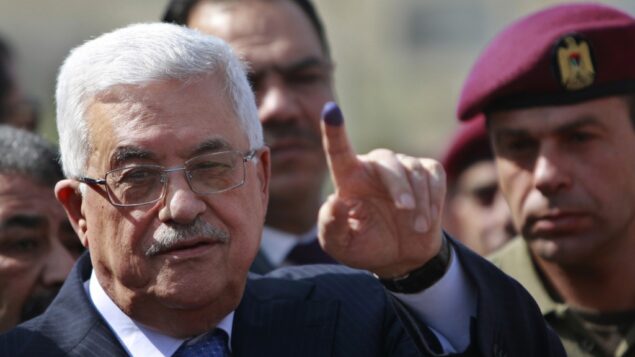 رئيس السلطة الفلسطينية محمود عباس يظهر اصبعه ملطخة بالحبر بعد الادلاء بصوته خلال الانتخابات المحلية في مركز اقتراع في مدينة رام الله بالضفة الغربية، 20 اكتوبر 2012 (AP / Majdi Mohammed)