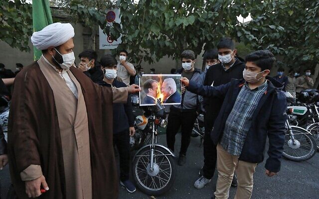 إيرانيون يحرقون صورة الرئيس الفرنسي إيمانويل ماكرون ورئيس الوزراء بنيامين نتنياهو خلال احتجاج خارج السفارة الفرنسية في طهران ضد تصريحات ماكرون دفاعا عن الرسوم الكاريكاتورية للنبي محمد، 28 أكتوبر 2020 (ATTA KENARE / AFP)