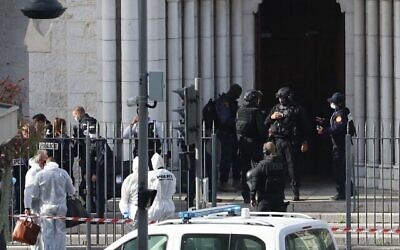 عناصر شرطة فرنسية من وحدة النخبة RAID تدخل كنيسة  نوتردام  في نيس بينما ينتظر عناصر شرطة التحليل الجنائي في الخارج بعد هجوم بسكين وقع في المكان، نيس، 29 أكتوبر، 2020. (Valery HACHE / AFP)