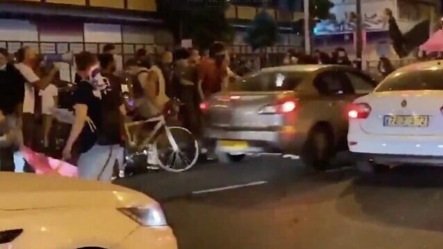 لقطة شاشة من مقطع فيديو لسيارة ، وسط الصورة ، وهي تصطدم بمتظاهرين مناهضين للحكومة خلال مظاهرة في تل أبيب، 1 أكتوبر ، 2020. (Twitter)