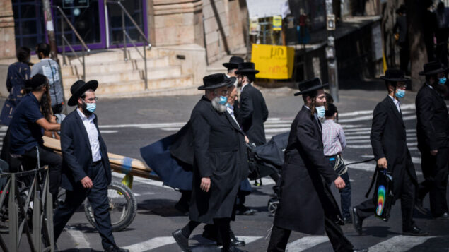 أشخاص يسيرون في حي مئة شعاريم اليهودي المتشدد في القدس، 1 أكتوبر 2020 (Yonatan Sindel / Flash90) أشخاص يسيرون في حي مئة شعاريم اليهودي المتشدد في القدس، 1 أكتوبر 2020 (Yonatan Sindel / Flash90)