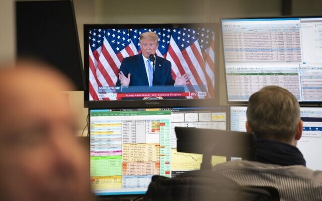 الرئيس الأمريكي دونالد ترامب يظهر على شاشة التلفزيون بينما يعمل المتداولون في البورصة في فرانكفورت أم ماين، غرب ألمانيا، 4 نوفمبر 2020 (FRANK RUMPENHORST / DPA / AFP)