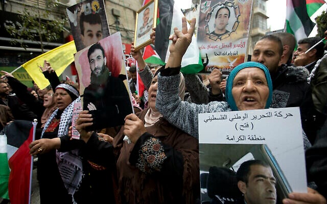 أقارب أسرى فلسطينيين في السجون الإسرائيلية يحملون صورا لهم خلال تظاهرة لإحياء "يوم الأسير" في مدينة رام الله بالضفة الغربية،  7 أبريل، 2019. (AP Photo/Majdi Mohammed)
