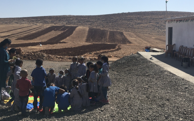 أطفال يلعبون أمام مدرسة رأس التين بالضفة الغربية، المهددة بالهدم من قبل الإدارة المدنية، 15 أكتوبر، 2020. (Aaron Boxerman / Times of Israel)