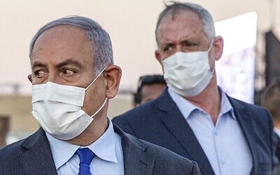 رئيس الوزراء بنيامين نتنياهو (وسط-يسار) وشريكه في الإئتلاف الحكومي، وزير الدفاع بيني غانتس (وسط-يمين)، يحضران حفل تخرج الطيارين الجدد في قاعدة ’حتساريم’ الجوية بالقرب من بئر السبع، في 25 يونيو 2020. (Ariel Schalit / POOL / AFP)