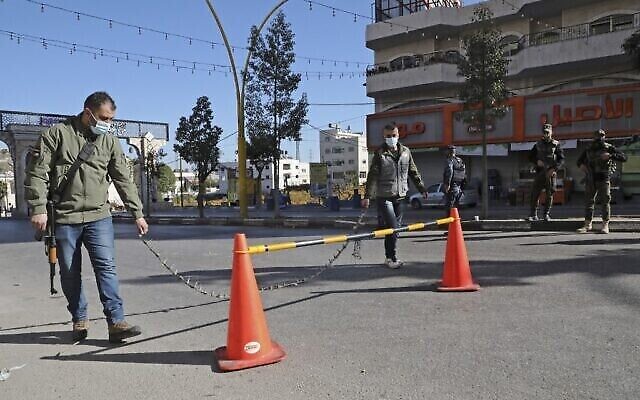 قوات الامن الفلسطينية تغلق المدخل الشمالي الرئيسي لفرض حظر التجول وسط جائحة كوفيد-19 في مدينة الخليل بالضفة الغربية، 11 ديسمبر، 2020. (HAZEM BADER / AFP) قوات الامن الفلسطينية تغلق المدخل الشمالي الرئيسي لفرض حظر التجول وسط جائحة كوفيد-19 في مدينة الخليل بالضفة الغربية، 11 ديسمبر، 2020. (HAZEM BADER / AFP)