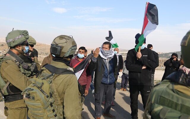 فلسطينيون يحتجون على السياسات الإسرائيلية وهجمات المستوطنين في جنوب تلال الخليل امام الجنود، 2 يناير 2021 (WAFA)