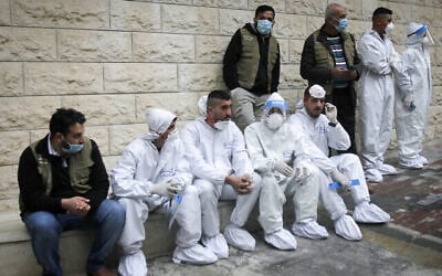 فلسطينيون يجلسون خلال افتتاح رئيس الوزراء الفلسطيني محمد اشتية مستشفى لكوفيد-19 في مدينة نابلس بالضفة الغربية، 16 يناير، 2021. (Nasser Ishtayeh / Flash90)