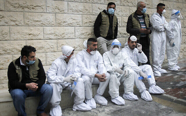 فلسطينيون يجلسون خلال افتتاح رئيس الوزراء الفلسطيني محمد اشتية مستشفى لكوفيد-19 في مدينة نابلس بالضفة الغربية، 16 يناير، 2021. (Nasser Ishtayeh / Flash90)
