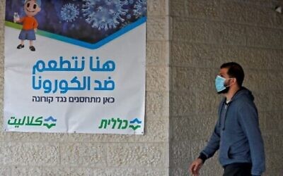 أحد سكان القدس الشرقية يصل لتلقي جرعة من لقاح فايزر-بيونتك ضد  فيروس كورونا  في خدمات الصحة الشاملة كلاليت في حي بيت حنينا، 3 شباط 2021. AHMAD GHARABLI / AFP)