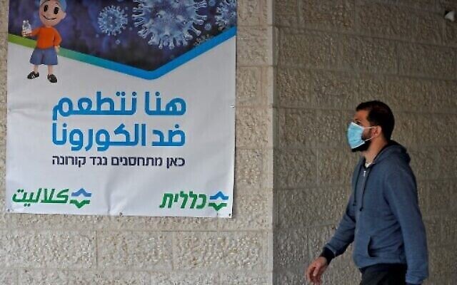 أحد سكان القدس الشرقية يصل لتلقي جرعة من لقاح فايزر-بيونتك ضد  فيروس كورونا  في خدمات الصحة الشاملة كلاليت في حي بيت حنينا، 3 شباط 2021. AHMAD GHARABLI / AFP)