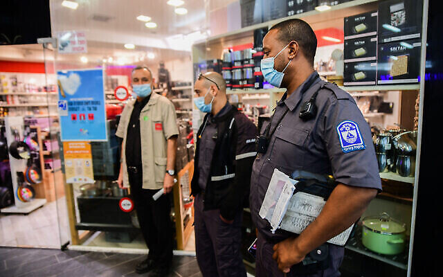 الشرطة والمفتشون في بلدية بات يام يفرضون قيود إغلاق كورونا في مركز تسوق في بات يام تم فتحه جزئيا في انتهاك للوائح الحكومية، 11 فبراير، 2021. (Avshalom Sassoni / Flash90) الشرطة والمفتشون في بلدية بات يام يفرضون قيود إغلاق كورونا في مركز تسوق في بات يام تم فتحه جزئيا في انتهاك للوائح الحكومية، 11 فبراير، 2021. (Avshalom Sassoni / Flash90)