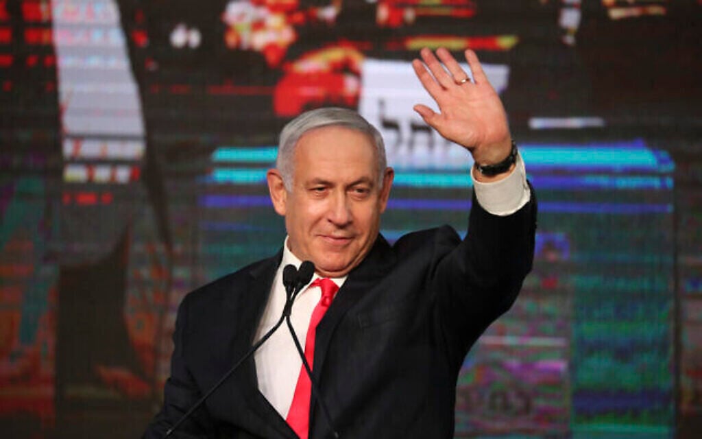 رئيس الوزراء بنيامين نتنياهو يلوح لمؤيديه بعد صدور النتائج الأولية للانتخابات البرلمانية في مقر حزب الليكود في القدس، 24 مارس 2021 (AP Photo / Ariel Schalit)