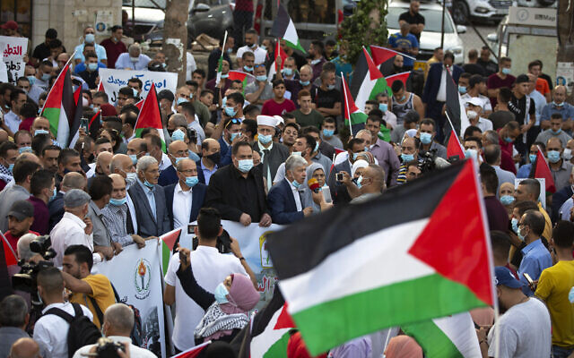 فلسطينيون يلوحون بالاعلام الوطنية خلال مظاهرة ضد تطبيع العلاقات بين الامارات والبحرين مع اسرائيل، في مدينة رام الله بالضفة الغربية، 15 سبتمبر 2020 (Majdi Mohammed / AP) فلسطينيون يلوحون بالاعلام الوطنية خلال مظاهرة ضد تطبيع العلاقات بين الامارات والبحرين مع اسرائيل، في مدينة رام الله بالضفة الغربية، 15 سبتمبر 2020 (Majdi Mohammed / AP)