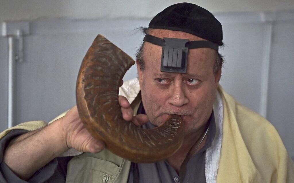 اليهودي الأفغاني زيبولون سيمينتوف يضرب في بوق الشوفار داخل كنيس يهودي في مبنى قديم في كابول، 5 أبريل 2021 (WAKIL KOHSAR / AFP)