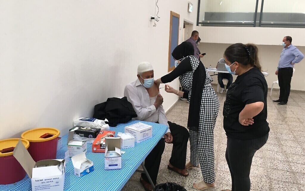 رجل يتلقى جرعته الثانية من اللقاح في محطة تطعيم مؤقتة في برطعة ، إسرائيل. (Uriel Heilman/ JTA)