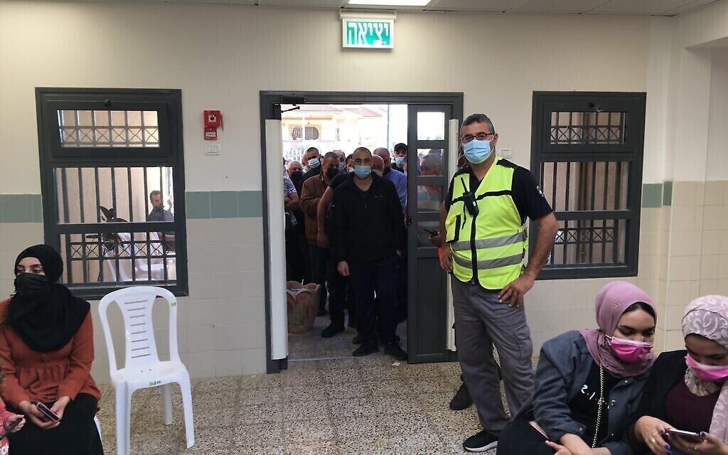 في محطة تطعيم ضد فيروس كورونا في بلدة برطعة العربية الإسرائيلية، ينتظر الفلسطينيون إلى جانب المواطنين الإسرائيليين على أمل الحصول على جرعة من جرعات اللقاح غير الكافية، 8 أبريل، 2021. (Uriel Heilman / JTA)