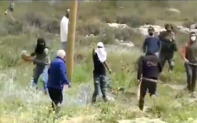 مستوطنون يهاجمون رجلا فلسطينيا في الضفة الغربية في مقطع فيديو نُشر في 3 أبريل، 2021. (Screenshot / Yesh Din)
