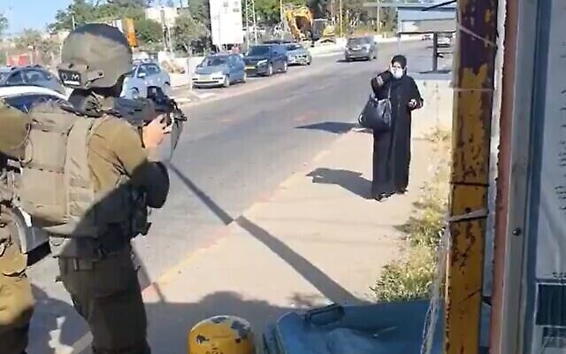 امرأة فلسطينية (على يمين الصورة) تقترب من جنود إسرائيليين عند مفرق غوش عتصيون في الضفة الغربية، في محاولة مزعومة لتنفيذ عملية طعن، 2 مايو، 2021. (screenshot: Twitter)
