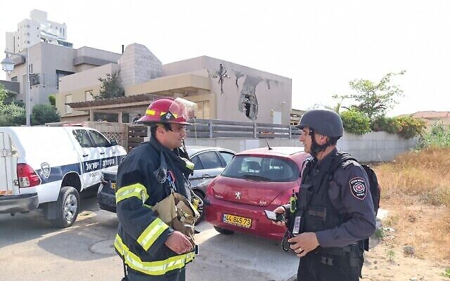 مسؤولو خدمة الإطفاء خارج كنيس في أشكلون أصيب بصاروخ، 16 مايو، 2021. (National Fire and Rescue Authority)