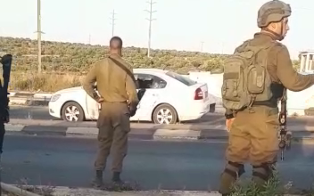 جنود إسرائيليون يقفون بجانب السيارة الفلسطينية التي يشتبه في محاولة ركابها تنفيذ عملية إطلاق نار عند مفرق تابوح في الضفة الغربية، 11 مايو 2021 (Screenshot)