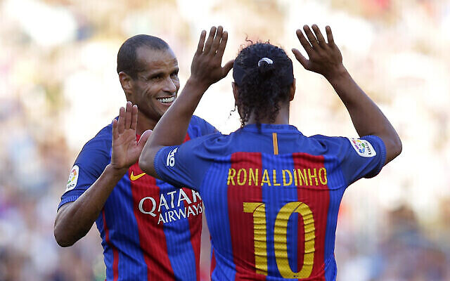 رونالدينيو، لاعب برشلونة السابق، على يمين الصورة ،وزميله في الفريق ريفالدو خلال مباراة ودية لكرة القدم بين أساطير برشلونة وأساطير مانشستر يونايتد في ملعب كامب نو في برشلونة، إسبانيا، 30 يونيو، 2017. (AP Photo / Manu Fernandez)