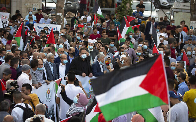 فلسطينيون يلوحون بالاعلام الفلسطينية خلال مظاهرة ضد تطبيع العلاقات بين الامارات والبحرين مع اسرائيل، في مدينة رام الله بالضفة الغربية، 15 سبتمبر، 2020. (Majdi Mohammed / AP)