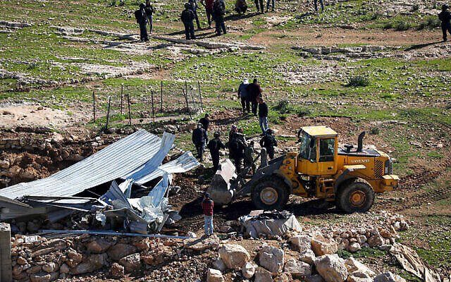 جرافة اسرائيلية تهدم سقيفة مزرعة فلسطينية في قرية مسافر يطا في الضفة الغربية، شباط 2020. (Wisam Hashlamoun / Flash90)