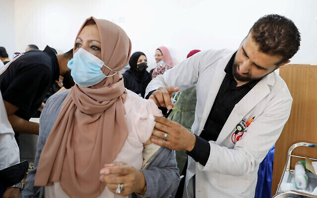 فلسطينيون يتلقون لقاح فايزر/بيونتك ضد كوفيد-19 في مدينة الخليل بالضفة الغربية، 27 مارس، 2021. (Wisam Hashlamoun / Flash90)