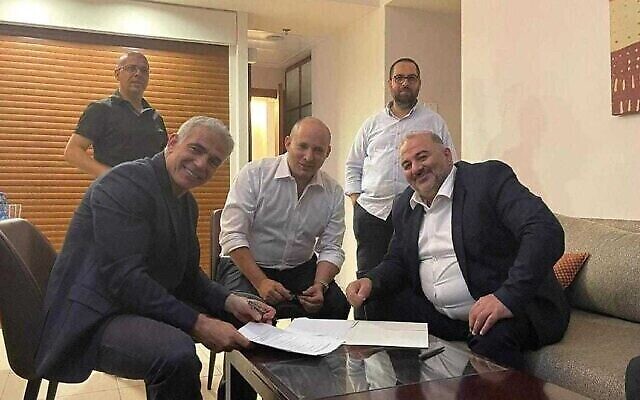 منصور عباس مع يائير لبيد ونفتالي بينيت خلال التوقيع على إتفاق الإتلاف الحكومي الذي إذا تمت المصادقة عليه سوف ينهي فترة حكم رئيس الوزراء بنيامين نتنياهو (مقدمة من القائمة العربية الموحدة)
