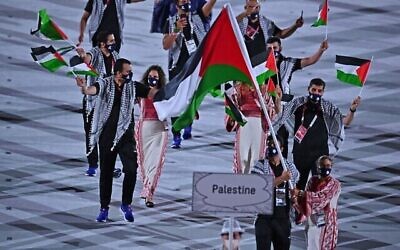 حاملة العلم الفلسطيني دانيا نور والوفد المرافق لها خلال حفل افتتاح دورة الالعاب الاولمبية طوكيو 2020، في الاستاد الاولمبي في طوكيو، 23 يوليو، 2021. (Ben STANSALL / AFP)