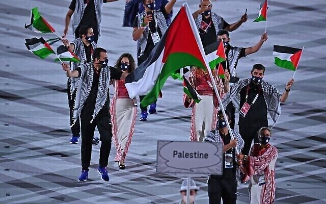 حاملة العلم الفلسطيني دانيا نور والوفد المرافق لها خلال حفل افتتاح دورة الالعاب الاولمبية طوكيو 2020، في الاستاد الاولمبي في طوكيو، 23 يوليو، 2021. (Ben STANSALL / AFP)