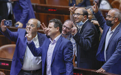 أعضاء الكنيست من "القائمة المشتركة" يحتفلون بعد تصويت الكنيست على رفض تمديد قانون لم شمل العائلات الفلسطينية، في القدس، 6 يوليو، 2021. (Yonatan Sindel / Flash90)