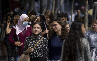 أشخاص ، بعضهم يرتدي الكمامات، يسيرون في شارع يافا في القدس، 25 يوليو، 2021. (Olivier Fitoussi / Flash90)
