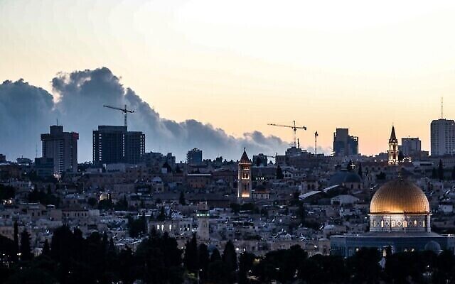 تظهر هذه الصورة المأخوذة من جبل الزيتون منظرا عاما لمدينة القدس القديمة مع قبة الصخرة في الحرم القدسي في المقدمة وسحابة من الدخان تتصاعد من حريق ضخم في الخلفية، 15 أغسطس، 2021.  (Ahmad GHARABLI / AFP)