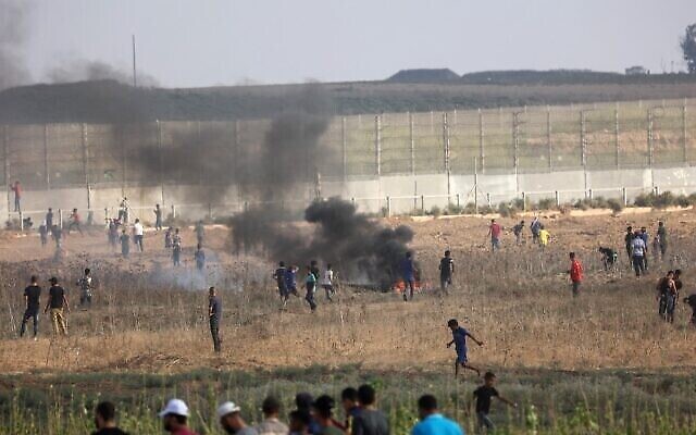 متظاهرون فلسطينيون يحرقون الإطارات وسط اشتباكات مع قوات الأمن الإسرائيلية في أعقاب مظاهرة عند السياج الحدودي مع إسرائيل، شرقي مدينة غزة، في 21 أغسطس، 2021. (SAID KHATIB / AFP)